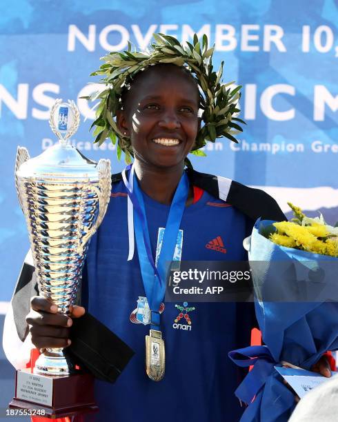 Nancy Joan Rotich of Kenya, 26, celebrates on the podium after winning the 31st Athens classic marathon, in a time of 2:41:38, on November 10, 2013 in Athens. AFP PHOTO /STR (Photo by AFP) (Photo by STR/AFP via Getty Images)
